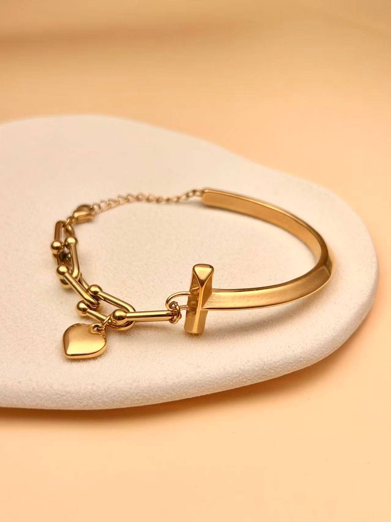 Pulseira dourada mista de corrente e aro com pendente de coração